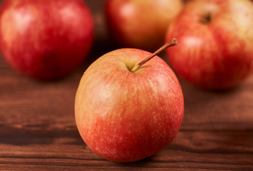 Fresh ripe red apples on a brown wooden background