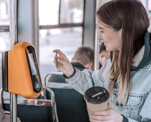 A young woman contactless pays for public transport.