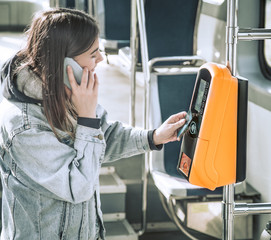 A young woman contactless pays for public transport.