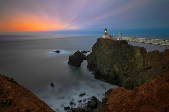 A view westward of Point Bonita Light House in the Marin Headlands of Northern California near San Francisco, after the sun has set with the blur of the ocean crashing on the waves below