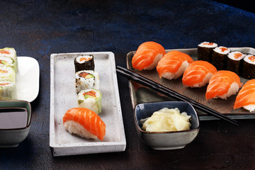 close up of sashimi sushi set with chopsticks and soy - sushi roll with salmon and sushi roll with smoked eel