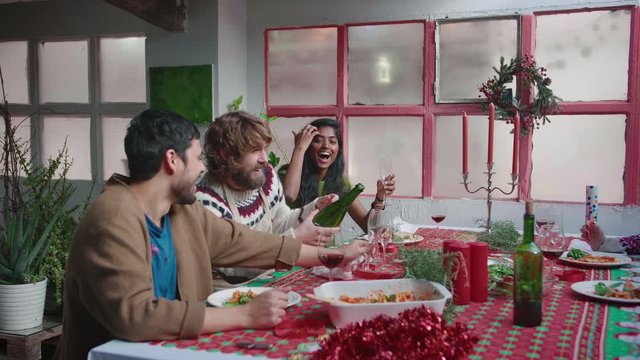 Party Celebration Together Gathered at the Table happy yong and joyful friends are laugthing and smiling onening and champain Eating, Drinking, Passing Dishes, Joking and Having Fun togeter at