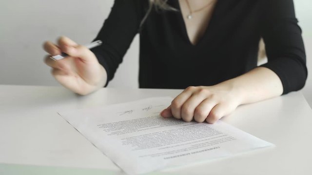 Businesswoman is signing cooperation agreement. Person heand signs the document