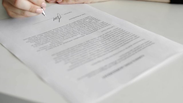 Businesswoman is signing consulting agreement. Person heand signs the document