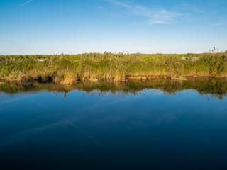  reflections of reeds in the river water and fishermen's cabins