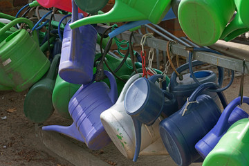 Blue watering cans hanging locked