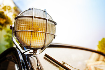 Fototapeta na wymiar Close up of old head light on rarity black car