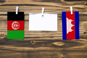 Hanging flags of Afghanistan and Cambodia attached to rope with clothes pins with copy space on...