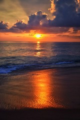 Obraz premium Phuket beach sunset, colorful cloudy twilight sky reflecting on the sand gazing at the Indian Ocean, Thailand, Asia.