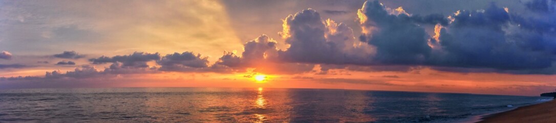 Obraz na płótnie Canvas Phuket beach sunset, colorful cloudy twilight sky reflecting on the sand gazing at the Indian Ocean, Thailand, Asia.