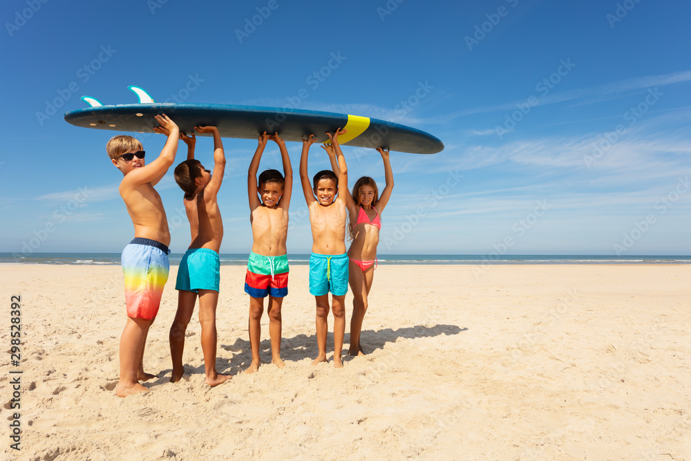 Wall mural Many kids carry surfboard on the beach to sea