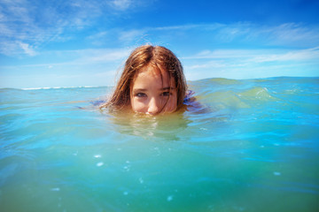 Half underwater portrait of a girl swim in the sea
