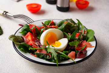 Healthy salad with prosciutto, tomato and egg