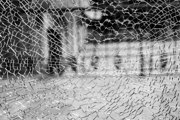 Abstract background of cobweb cracks The texture of the broken cracks. Close-up of a cracked glass. Dirty scratched broken glass of a office door