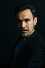 Portrait of a mature, stylish man on black studio background