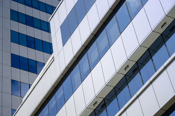 Fototapeta na wymiar Modern architectural background of metal panels and blue glazing close up