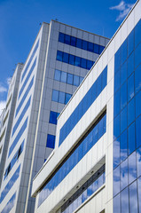 Architectural background, fragment of a modern office building against blue sky