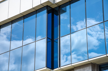 Obraz na płótnie Canvas Modern architectural background of metal panels and blue glazing close up