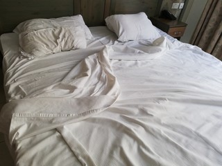 Fototapeta na wymiar Unmade bed in hotel room