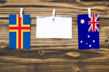 Hanging flags of Aland Islands and Australia attached to rope with clothes pins with copy space on...