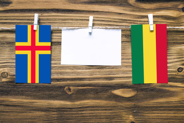 Hanging flags of Aland Islands and Bolivia attached to rope with clothes pins with copy space on...