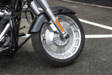 Fototapeta na wymiar Cast drive. Front wheel. The fork on the bike. Classic motorcycle. Detail of a chopper. Stylish design. Two-wheeled vehicle. Tire and wheel drive.