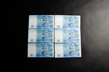 Fototapeta na wymiar The Ukrainian hryvnia denominated five, ten, twenty hryvnias scattered and neatly linked. Hryvnia in male hands and in a wallet. Theft of Ukrainian hryvnia money