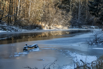 A river with ice and reflections and trees in winter