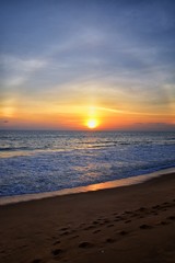 Phuket beach sunset, colorful cloudy twilight sky reflecting on the sand gazing at the Indian Ocean, Thailand, Asia.