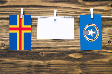 Hanging flags of Aland Islands and Northern Mariana Islands attached to rope with clothes pins with...