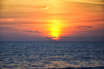 Fototapeta premium Phuket beach sunset, colorful cloudy twilight sky reflecting on the sand gazing at the Indian Ocean, Thailand, Asia.