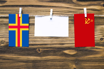 Hanging flags of Aland Islands and Soviet Union attached to rope with clothes pins with copy space...