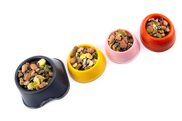 a variety of nutritious, balanced granulated food for rodents in bowls isolated on white background