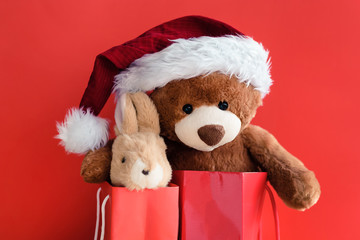 Christmas card with Teddy and banny in red gift bags.  With  holiday decoration and presents