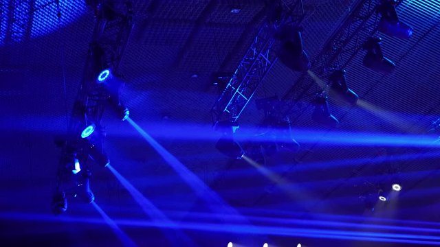 Ramp with lighting equipment. Blue spotlights on steel construction. Lightning equipment. The stage spotlights projecting lights during a live event. Live concerts and events. Stage lights