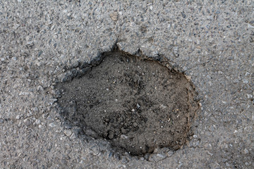 large pit on the road filled with water, the concept of bad broken roads, maintenance and repair of the road surface