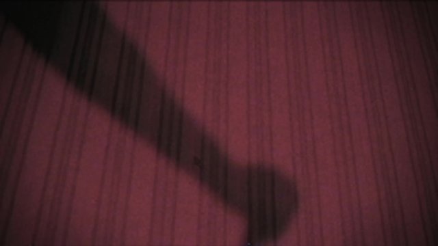 Vintage effect. A man kills his victim with a knife.  Archive. Retro. Old film. Murder. Shadow of the criminal on the wall. Halloween.