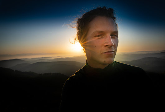 M&auml;nnerportrait bei Sonnenuntergang am Berggipfel