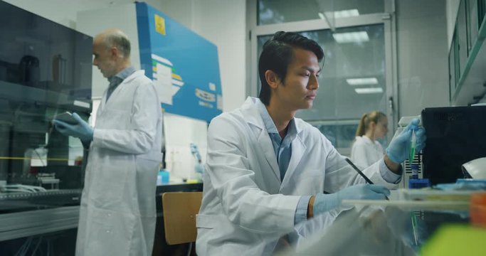 The scientists are working on a research of new pharmaceutical medicaments creation in a laboratory.