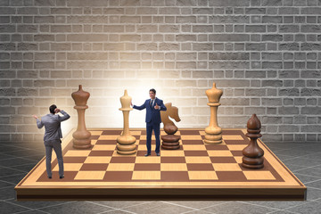 Businessman in large chess board in strategy concept