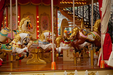 Fototapeta premium Old carousel with horses in a holiday autumn evening park with nobody