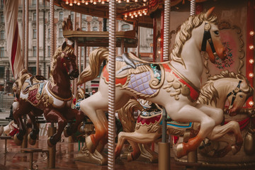 Old carousel with horses in a holiday autumn evening park with nobody