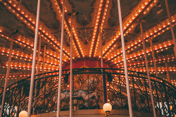 Obraz premium Old carousel with horses in a holiday autumn evening park with nobody