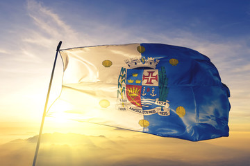 Angra dos Reis of Brazil flag waving on the top sunrise mist fog