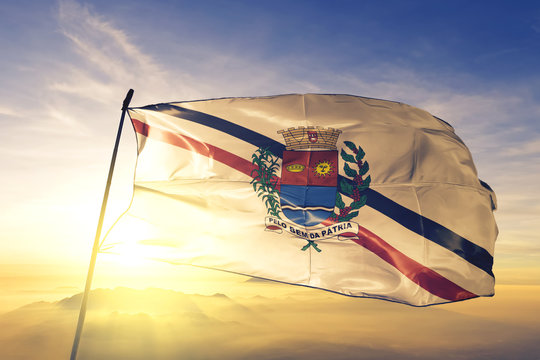 Araras of Brazil flag waving on the top sunrise mist fog