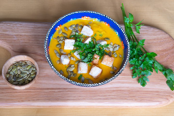 vegetarian pumpkin soup with croutons green parsley and pumpkin seeds