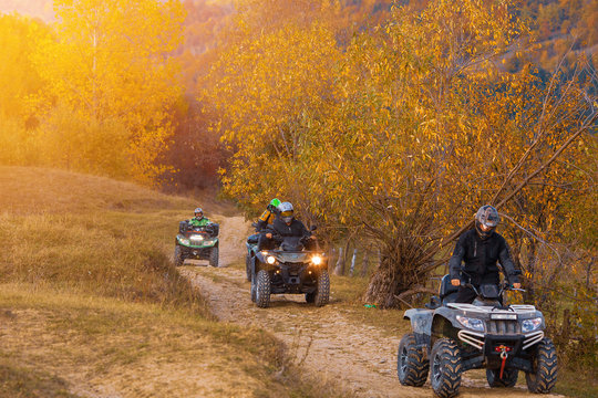 All terrain vehicles, quad bikes, atv, riding through beautiful rural scenery in autumn