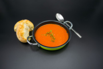 mediterrane Tomatensuppe schlicht angerichtet auf schwarzem Hintergrund.