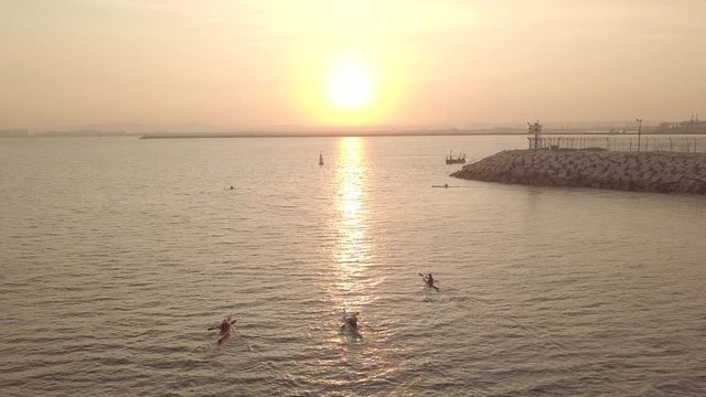 Long, narrow and fast racing sea kayaks. Early morning on a background of amazing sunrise.