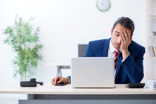 Young male businessman sitting in the office